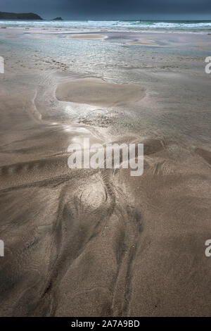 A dark marks left in the sand by a receding tide on Fistral Beach in Newquay in Cornwall. Stock Photo