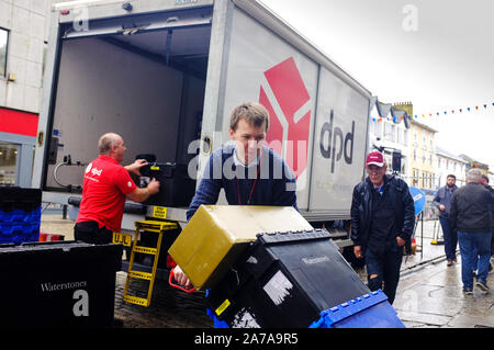A DPD delivery van being unloaded and delivering Plastic boxes to a Waterstones store in Boscawen Street in Truro City centre in Cornwall. Stock Photo