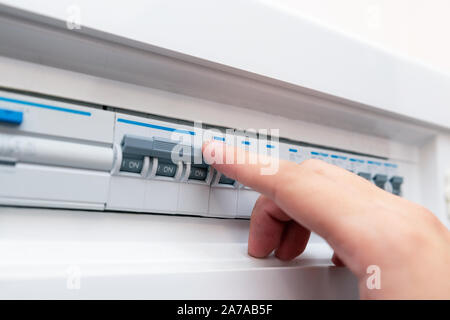 The man disables the current fuses. Electrical devices protection Stock Photo