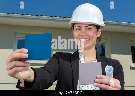 female architect holding colour sample outside of residential property Stock Photo