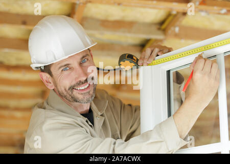 man measuring window prior to installation Stock Photo