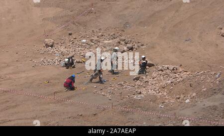 Enginers of 4M defense with protective gear attach explosives to mines in old Syrian minefield just before clearing the mines on Gofra beach in the sea of Galilee, Israel Stock Photo