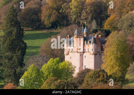 Craigievar Castle in Aberdeenshire Nestled Amongst Trees Displaying Vibrant Autumn Colours Stock Photo