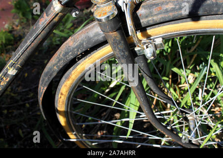 Closeup of an abandoned old bicycle with yellow tires on its wheels Stock Photo
