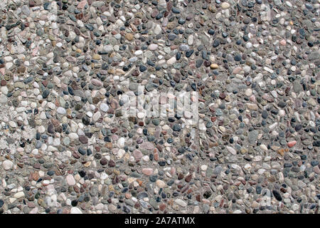 Beautiful stone wall background texture. pebble texture in concrete, small pebbles on the wall, on the floor. Stock Photo