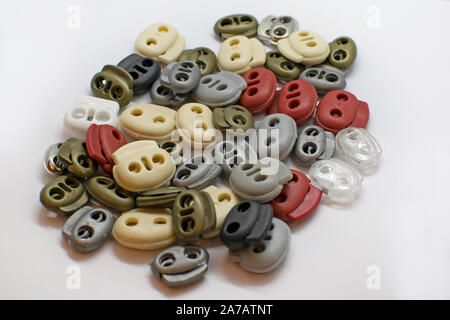Catch clips for adjusting length and volume. Two-hole plastic retainer pig round round multi-colored. Stock Photo