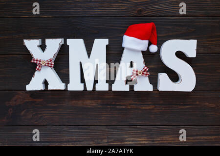 Title Xmas with wooden white letters on brown wooden background. Christmas festive card, holidays Stock Photo