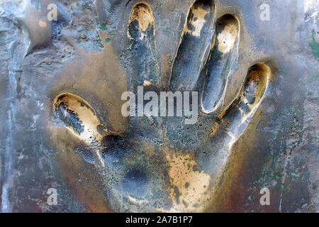 Prints of human hand. The imprint of the left palm on the surface of bronze close-up. Stock Photo