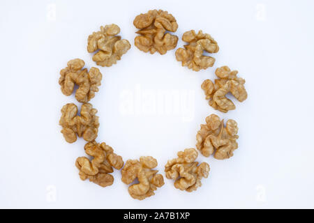 Peeled walnut halves (butterfly) close-up. Circle made of walnuts on a white background. Useful products, mockup. Stock Photo