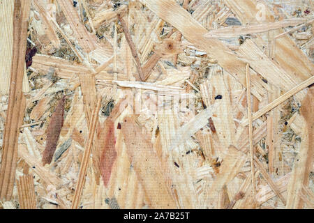 Construction plate for finishing and facing works close-up. Light brown construction plate OSB background. OSB texture of the material - recycled comp Stock Photo