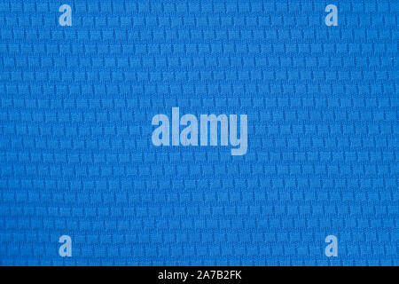 Blue polyester fabric background. A fragment of a t-shirt for sports. Close-up polyester, synthetic fabric for sewing clothes. Stock Photo