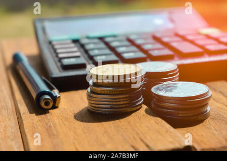 money from different countries in background, calculator, ballpen and coins are on it,top view of coins and pen Stock Photo