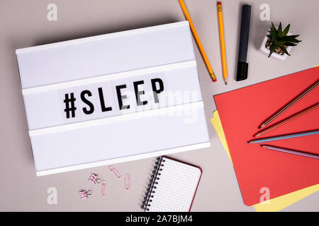 Hashtag with word sleep. Fatigue, rest and holidays concept. White lightbox on a grey office desk Stock Photo