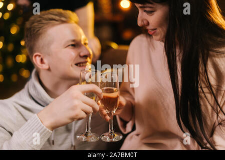 Young couple clinking with champagne glasses and celebrating new year Stock Photo