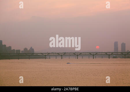 Seoul, South Korea. The sunset over the Han River covered with a thick haze of smog in late summer. Stock Photo
