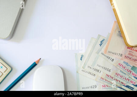 Fifty dollars and ten dollars Singapore and passports and calculators with computer laptop on a white background Stock Photo