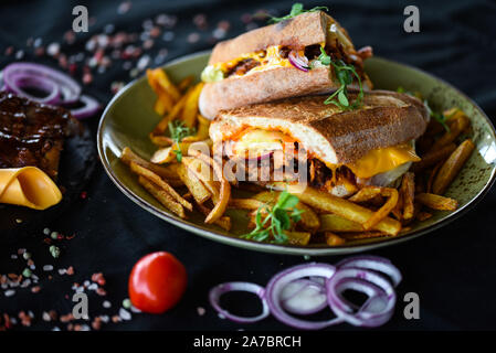 tasty ribs sandwich with french fries and fresh vegetables Stock Photo