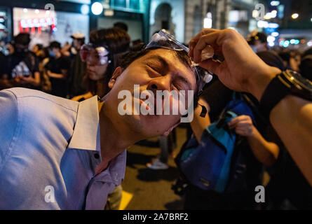 Hong Kong, China. 31st Oct, 2019. A protester receives medical aid after police sprayed with pepper spray in Central district, Hong Kong. Protesters at Halloween march in Hong Kong island despite police banned rallies and confront them during the night. Credit: SOPA Images Limited/Alamy Live News Stock Photo