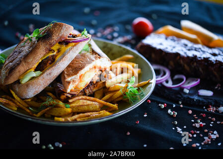 tasty ribs sandwich with french fries and fresh vegetables Stock Photo