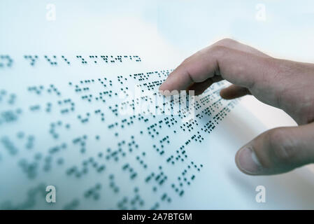 Hand of a blind person reading a text in the language of the blind, Braille Stock Photo