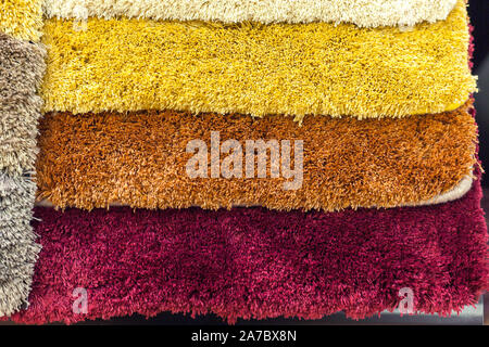 samples of multi-colored carpets on the shelves Stock Photo