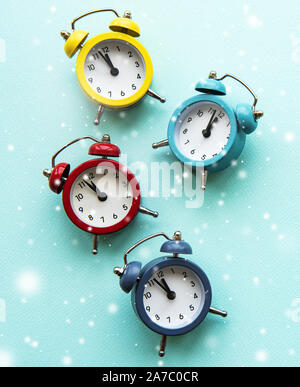 Flat lay Christmas composition with color alarm clocks  on light blue background. Stock Photo