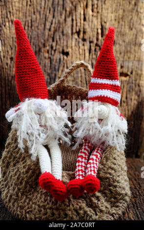 Concept celebration winter seasonal with two red Christmas gnome ornament relax together, cute handmade stuffed toy wear long hat, white beard Stock Photo