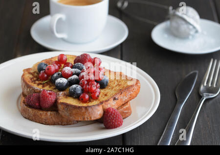 Good breakfast background.  French toasts with berries and icing sugar  cup of coffee on wooden table. Stock Photo