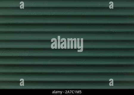 Abstract pattern of lines on dark green background. Vintage texture of grunge metal jalousie. Corrugated metallic surface. Ribbed background with stri Stock Photo