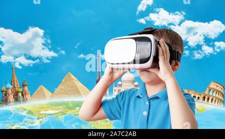 The concept of using virtual reality headsets. Boy holding virtual reality glasses. In the background is a earth with famous world sights. Copy space Stock Photo