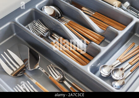 Stylish cutlery with wood-effect handles in organizer. Scandinavian style, hygge Stock Photo