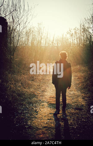 lonely man walking at sunset in a forest, mysterious person walks in abandoned places