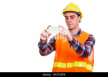 Portrait of young handsome man construction worker taking picture with phone Stock Photo