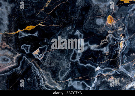 Dark onyx background with cracks. Colorful natural stone texture. Stock Photo