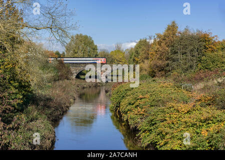 An EMR Regional train crossing the Sankey Brook in Sankey Valley Park, Warrington. Stock Photo