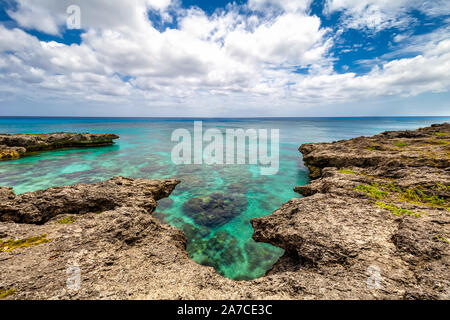 Background view of shallow turquoise waters with coral reefs underneath the surface and fringing reefs encircling it above the surface. Clear horizon Stock Photo