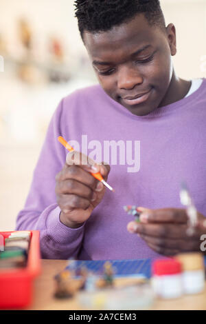 Teenage Boy Painting War Game Model Figures At Home Stock Photo