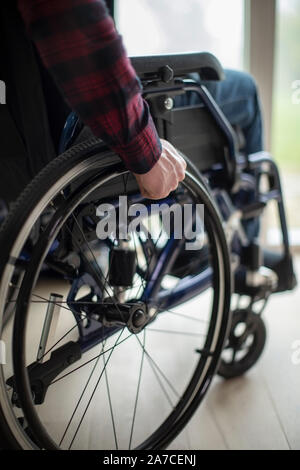 Close Up Of Man Sitting In Wheelchair At Home By Window Stock Photo