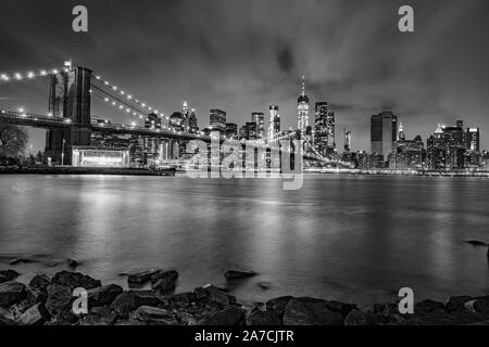 Long exposure of Brooklyn Bridge and Manhattan skyline seen from Brooklyn at night, New York Stock Photo