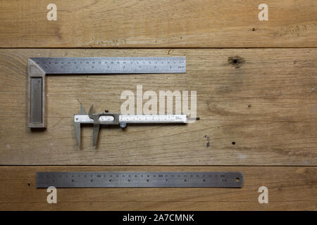 90 degree 25cm length stainless steel L-square angle ruler, vernier caliper, 30cm length straight edge metal ruler on wooden table background Stock Photo