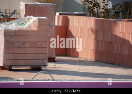 hollow brick wall unter construction and stack of clay blocks, hollow clay blocks  wall on construction site Stock Photo
