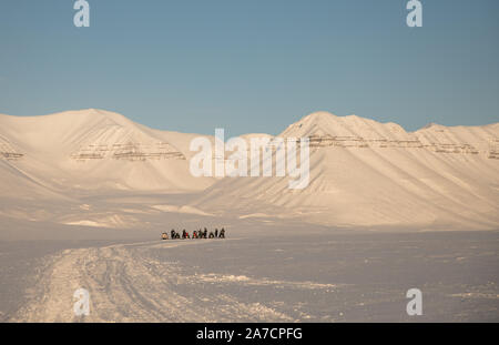 Arctic winter landscape with a group of people on a snowmobile expedition Stock Photo