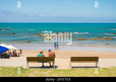 Salvador, Brazil - Circa September 2019: Senior couple sitting on a bench at the beach in Itapua Stock Photo