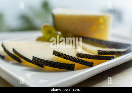 Spanish sheep cheese served with white grapes on andalusian style table outside with sea view Stock Photo