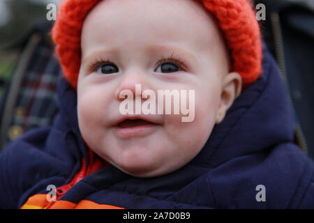 Baby dressed for cold, wet weather, U.K Stock Photo