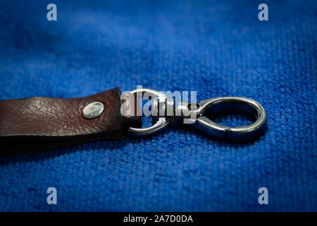Select focus Leather key chain with box on blue fabric background Stock Photo
