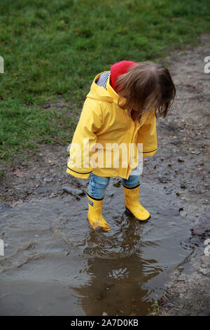 Toddler in a muddy puddle Stock Photo