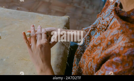 Woman potter making ceramic souvenir penny whistle in pottery workshop Stock Photo