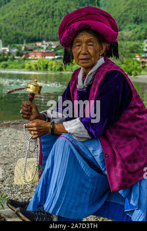 Mosuo Women praying by the water of Lugu Lake in XiaLuoShi, Lugu Lake, Yunnan, China Stock Photo