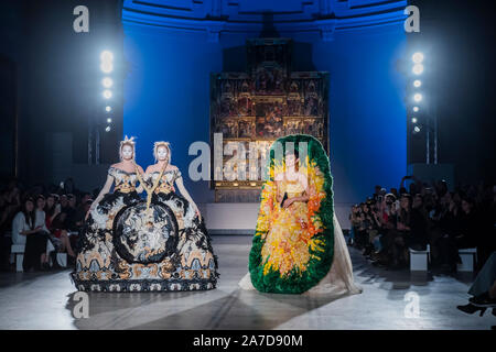 V&A, London, UK. 1st November 2019. Guo Pei’s first ever runway show in the UK, staged to celebrate the 20th anniversary of the V&A’s Fashion in Motion series. Taking place in the dramatic setting of the museum’s Raphael Gallery, models wear colourful pieces from the designers’ AW 2019/20 Alternate Universe Couture collection. Credit: Guy Bell/Alamy Live News Stock Photo